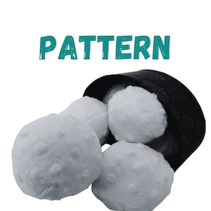 May include: Four white plush balls with a textured surface, sitting inside a black fabric container. The container has a floral pattern. The word "PATTERN" is written in teal above the container.