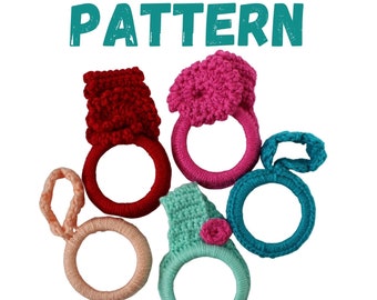 May include: Five crocheted rings in different colors, including red, pink, teal, and light blue. Each ring has a crocheted flower on top. The rings are arranged in a circle.