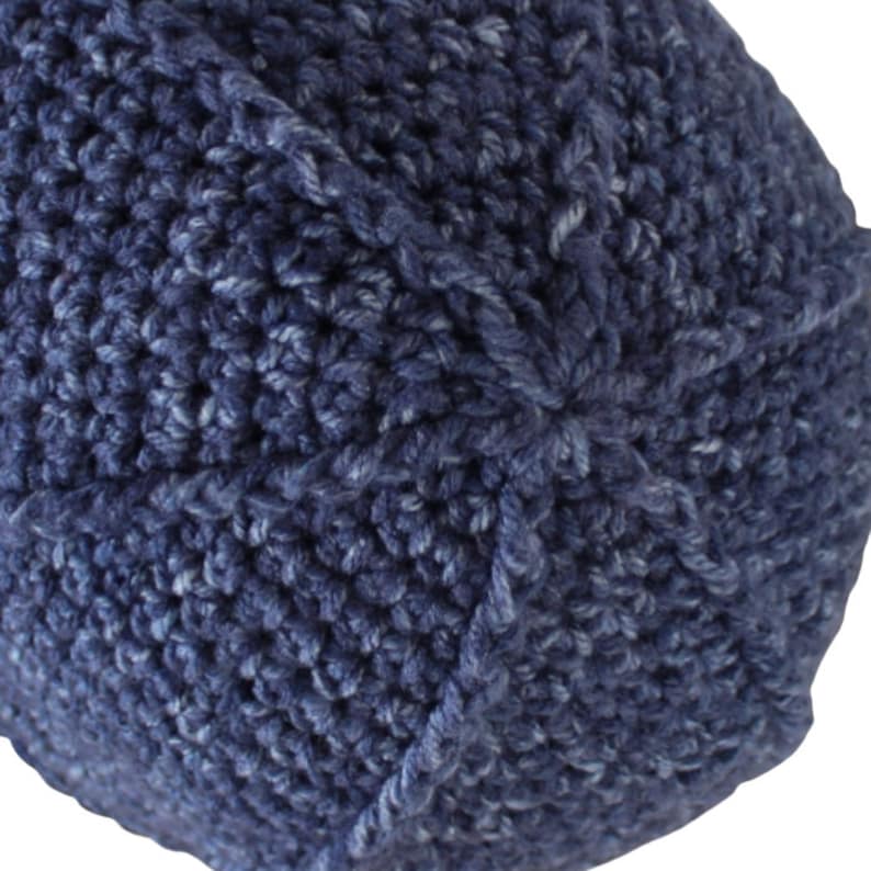 Puede incluir: Primer plano de un gorro de punto azul. El gorro est&aacute; hecho con un hilo texturizado y tiene un dise&ntilde;o sencillo.