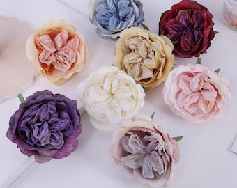 May include: Assortment of seven artificial flower heads in various colors, including light blue, burgundy, peach, beige, white, pink, and purple. The flowers are all closed and have a realistic appearance.