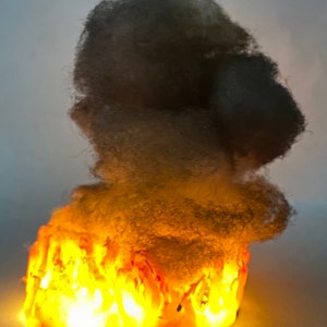 May include: A decorative tabletop sculpture of a fluffy white cloud with a glowing orange base, resembling a fire.