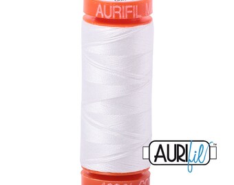 May include: A spool of white Aurifil thread with an orange label that says "Aurifil 100% Cotton" and "Made in USA".