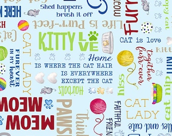 May include: A light blue fabric with a repeating pattern of cat-themed words and illustrations. The words include "Cat Lady", "Meow", "Pawsit", "Home is Where the Cat Hair is Everywhere Except the Cat", "Life is Purr-fect", "Furry", "Together Forever", "Faithful Friend", "Think", "Cat is Love", "Kitty Love", "Shed Happens Brush it Off", "Cat Got Hairballs", "Here K", "No Pawp", "Hiss", "Alles and Cute", "Cat Nip", "I'm a Copy Cat", "You're If", "Meow", "Cat", "Cat Lady". The illustrations include cats, yarn balls, hearts, paw prints, and a bowl of cat food.