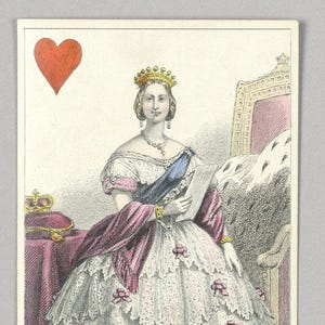 May include: A playing card featuring the Queen of Hearts with a portrait of Queen Victoria wearing a crown and a white dress with lace and pink ribbons. The card is red with a large heart in the top left corner.