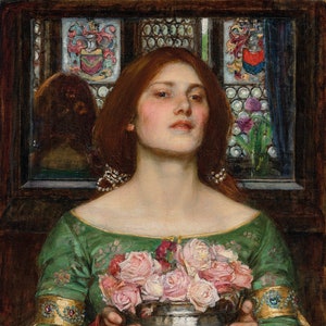 May include: A woman in a green dress with a floral pattern holds a silver bowl filled with pink roses. She is standing in front of a window with stained glass panels.