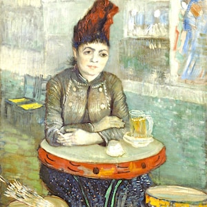 May include: A woman wearing a red hat sits at a table with a glass of beer. The table is round and has a red and yellow design. The woman is wearing a brown jacket and a blue skirt. The background is a blurry image of a cafe.