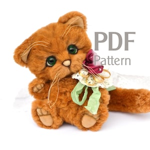 Könnte beinhalten: Ein Plüschtier in Form einer orangefarbenen Katze mit grünen Augen, das eine rosa Blume und ein grün-weißes Band hält. Das Spielzeug sitzt auf einer weißen Oberfläche. PDF-Muster.