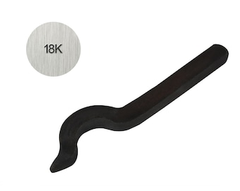Puede incluir: Un punzón de metal negro con un mango curvo y una punta puntiaguda. El punzón está marcado con el texto "18K".