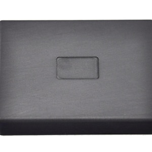 May include: A black rectangular graphite mould with a rectangular cutout in the centre.