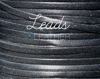 May include: Close-up of a spool of black leather cord. The cord is smooth and has a subtle sheen.  Leads Leather.