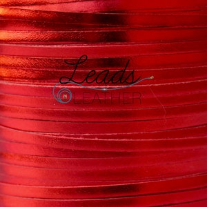 May include: A close-up of a spool of red leather cord. The cord is shiny and has a metallic finish. The spool is labeled "Leads Leather".