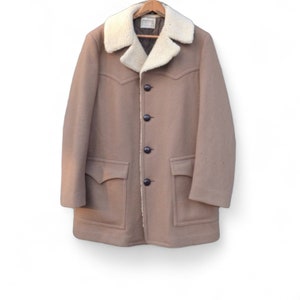 May include: A tan wool coat with a faux fur collar and four black buttons. The coat has two large pockets on the front.