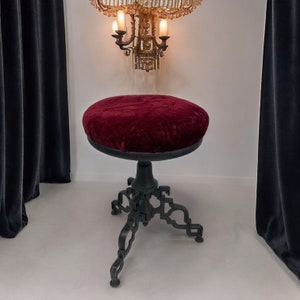 Vintage goth Spanish Revival adjustable stool with cast iron base and a red velvet round seat.