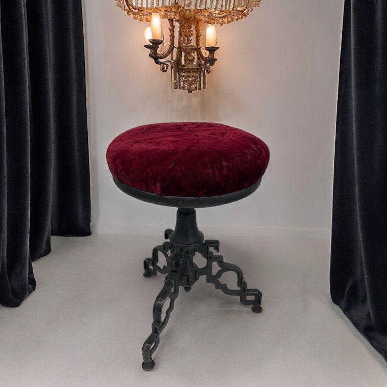 Vintage goth Spanish Revival adjustable stool with cast iron base and a red velvet round seat.