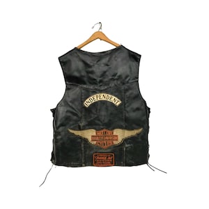 May include: Black leather motorcycle vest with a Harley Davidson patch, an "Independent" patch, and an "Orange Jim" patch.