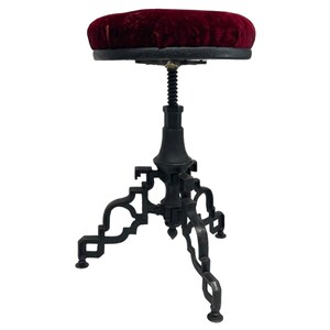 Vintage goth Spanish Revival adjustable stool with cast iron base and a red velvet round seat.