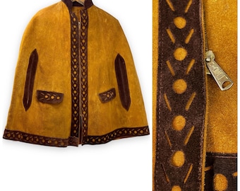 May include: A mustard yellow suede cape with brown leather trim and a zipper closure. The cape has a stand-up collar and two pockets. The trim features a repeating pattern of circles and lines.