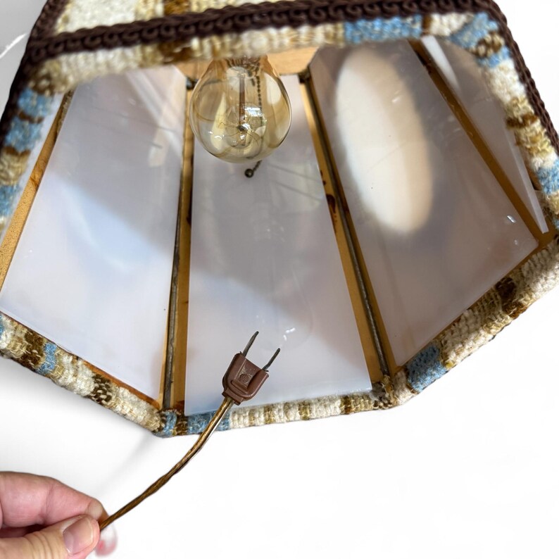 Vintage swag lamp with hexagonal shape and oval cutout, hanging on chain against a white background.