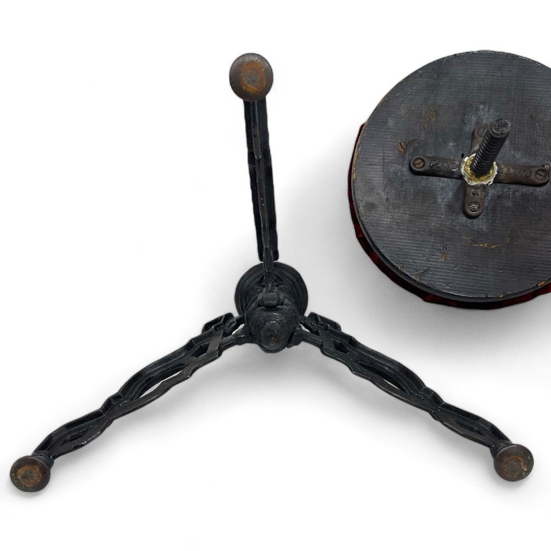 Vintage goth Spanish Revival adjustable stool with cast iron base and a red velvet round seat.