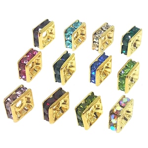 May include: Assortment of 12 gold-toned square bead spacers with different colored rhinestones. Each spacer has a hole in the center for stringing.
