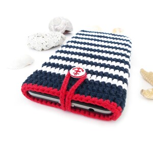 Marine inspired crocheted phone case made of eco-friendly durable mercerized cotton yarn in Navy Blue with White stripes and Red pinstripe on the top. Phone pouch is closed with White plastic button with Red anchor.
