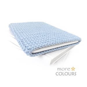 May include: A light blue knitted laptop sleeve with a textured pattern. The sleeve is folded over a white surface.