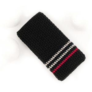Puede incluir: Funda de tel&eacute;fono de crochet negro con rayas blancas y rojas.