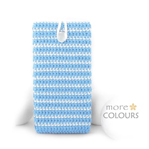 May include: A rectangular crochet pouch featuring horizontal stripes of light blue and white yarn. The pouch is secured at the top center with a single white button and a loop closure. The text "more COLOURS" is visible in the lower right corner.