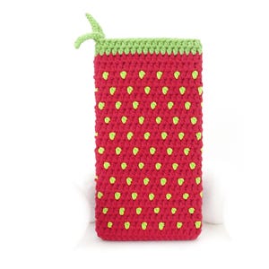 May include: A red crocheted pouch with a green top and green dots. The pouch is shaped like a strawberry.