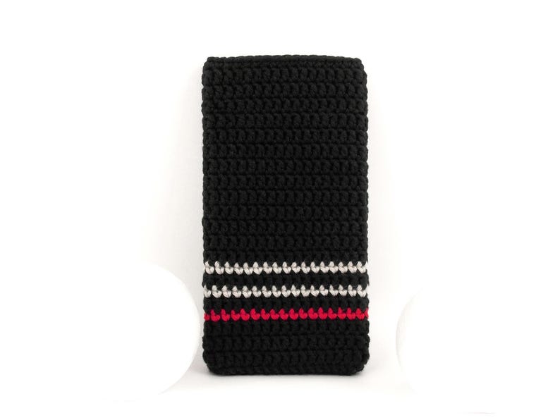 Puede incluir: Corbata de crochet negra con rayas blancas y rojas.