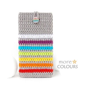 Puede incluir: Funda de teléfono tejida a mano en gris, blanco, morado, turquesa, verde, amarillo, naranja y rojo. Cuenta con un cierre de botón y el texto "more COLOURS".