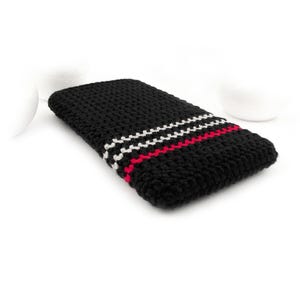 Puede incluir: Funda de tel&eacute;fono de crochet negro con rayas rojas y blancas.