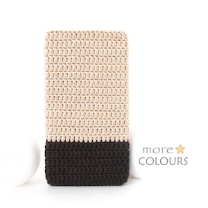 Puede incluir: Una funda para teléfono de crochet beige y marrón con un patrón texturizado. La funda tiene una sección superior beige y una sección inferior marrón.