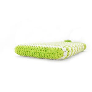 Puede incluir: Un estuche rectangular elaborado con hilo verde lima y blanco en un patr&oacute;n de punto de ganchillo denso. El art&iacute;culo presenta una construcci&oacute;n gruesa y texturizada con un cierre de bot&oacute;n blanco visible en el borde superior del tejido plano.