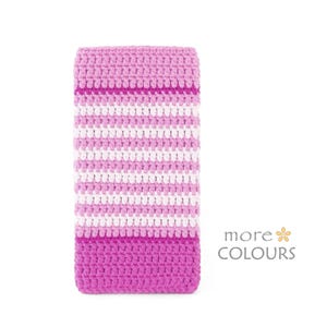 May include: A rectangular crochet sleeve featuring horizontal stripes in shades of light pink, white, and magenta. The textured yarn pattern covers the entire surface. The text "more COLOURS" with a small flower icon is visible in the bottom right corner.