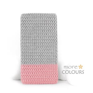 May include: A gray and pink crocheted baby blanket. The blanket is made with a textured stitch and has a two-tone color scheme.