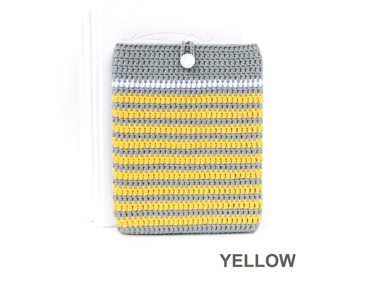 Crocheted e-reader soft case made of Grey durable cotton yarn with Yellow stripes and White stripe above them. The e-reader cover closes with a White plastic button and a strong loop.