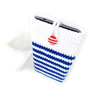 Puede incluir: Una funda de teléfono de crochet a rayas blancas y azules con un botón rojo y blanco.