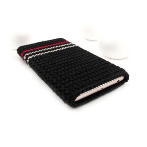 Puede incluir: Funda de tel&eacute;fono de crochet negro con rayas rojas y blancas. La funda est&aacute; dise&ntilde;ada para adaptarse a un tel&eacute;fono inteligente.