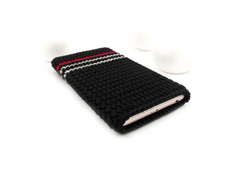 Puede incluir: Funda de tel&eacute;fono de crochet negro con rayas rojas y blancas. La funda est&aacute; dise&ntilde;ada para adaptarse a un tel&eacute;fono inteligente.