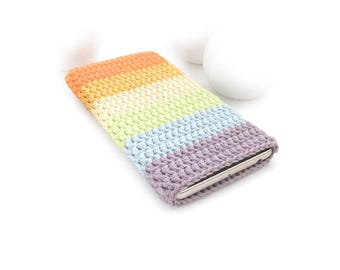 Puede incluir: Una funda de ganchillo rectangular para teléfono con rayas horizontales en tonos pastel de naranja, amarillo, verde claro, azul claro y lavanda. La funda está hecha con un punto texturizado y contiene un teléfono inteligente fino.