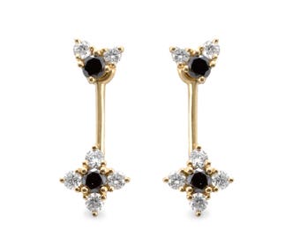 Könnte beinhalten: Ein Paar goldene Ohrringe mit schwarzen und weißen Diamanten. Die Ohrringe haben oben einen kleinen Diamantenhaufen und unten einen größeren Diamantenhaufen.