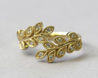 May include: A gold ring featuring a delicate design of two intertwined branches with small diamonds set in each leaf.