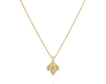 Op de afbeelding: Een delicate gouden ketting met een klein hangertje met drie kleine diamanten. Het hangertje heeft de vorm van een gestileerde bloem.