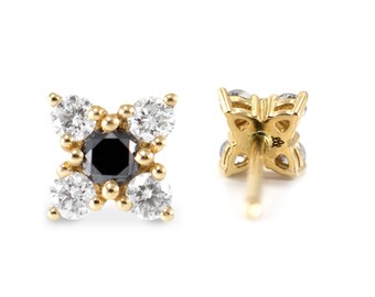 May include: A pair of gold earrings with a black diamond in the center and four smaller white diamonds surrounding it. The earrings are set in a four-pointed star shape.