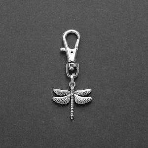 May include: A silver dragonfly keychain with a silver metal loop.