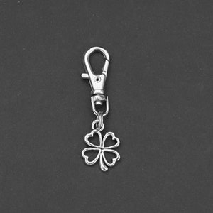 May include: Silver four-leaf clover keychain with a silver spring clasp.