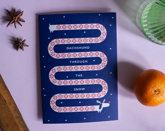Mignonne carte de Noël teckel à travers la neige chien saucisse