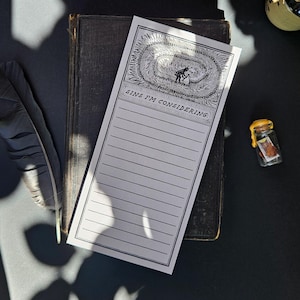 May include: A rectangular notepad with a white background and black ink. The top features a detailed illustration of a figure in a field, followed by the text SINS I'M CONSIDERING: above a series of horizontal lines for writing. The notepad is bordered.