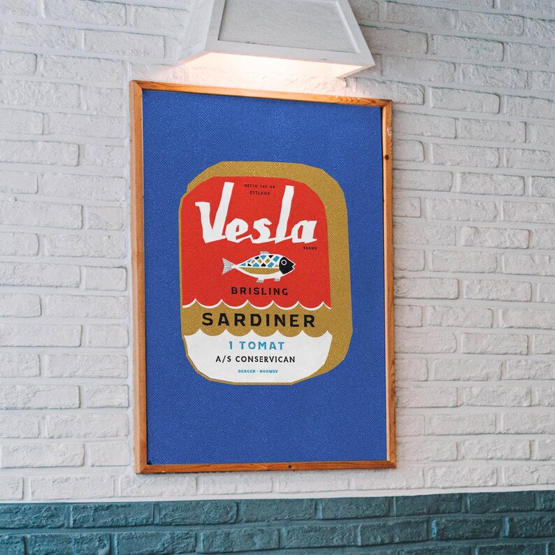 Puede incluir: Una ilustraci&oacute;n de estilo vintage de una lata de sardinas. La lata es roja, dorada y blanca con el texto "Vesla Brisling Sardiner 1 Tomat A/S Conservican" impreso en ella. La lata presenta una ilustraci&oacute;n estilizada de un pez.